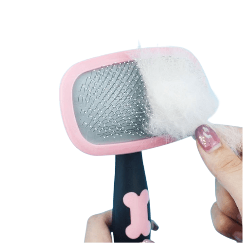 hand_removing_fur_from_pink_360_degree_pet_brush.png